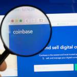 Lupa powiększająca skierowana na logo giełdy kryptowalut Coinbase